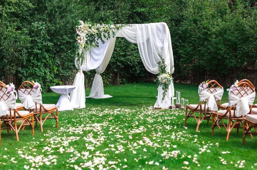 A wedding set up in the grass with flowers.